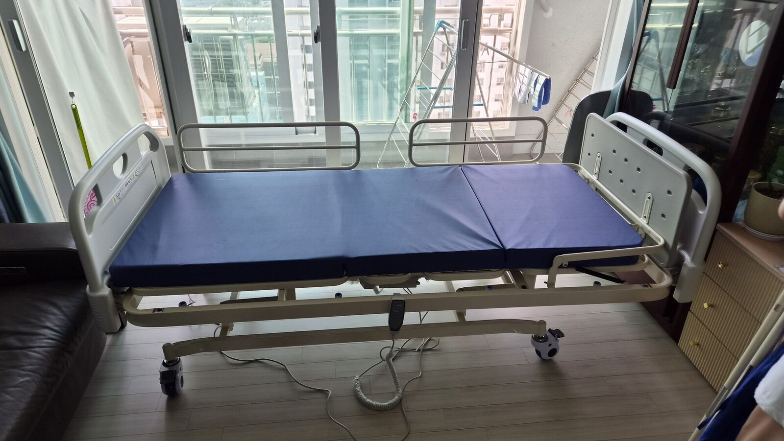 세종 전동침대대여 안내용 참고사진 - 거실 창가에 설치된 파란 매트리스 전동침대